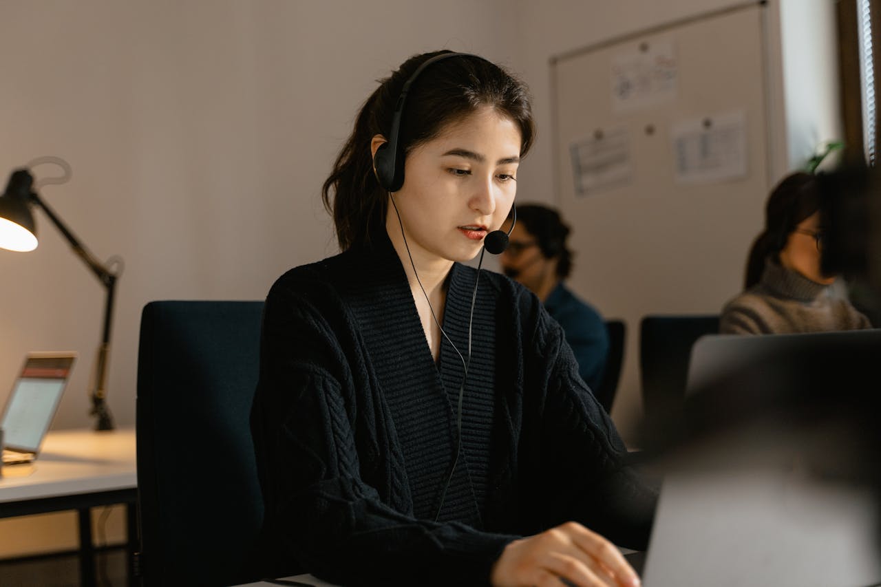 Woman in a Black Top Wearing a Black Headset<br />
